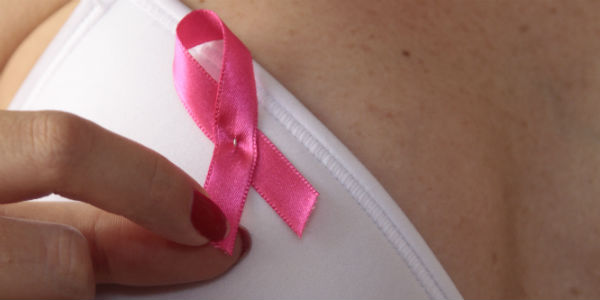 Imagem de mulher com fita rosa em referência ao Câncer de mama