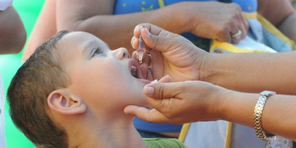 Foto de criança tomando gotinhas da vacinação (Foto: Hélia Scheppa / Acervo JC Imagem)