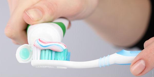 Imagem de pessoa colocando pasta de dente na escova de dente (Foto: Photl.com)