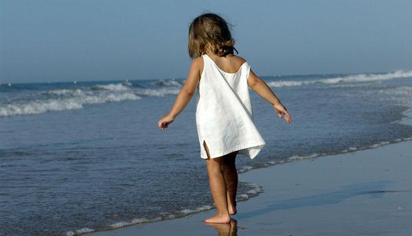 Imagem de criança com vestido branco na praia (Foto ilustrativa: Free Images)