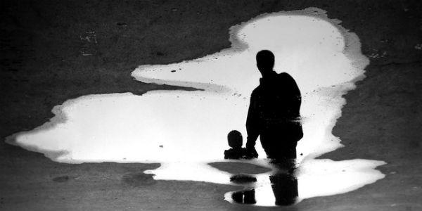 Imagem ilustrativa de pai e filho refletida em uma poça de água (Foto: Free Images)
