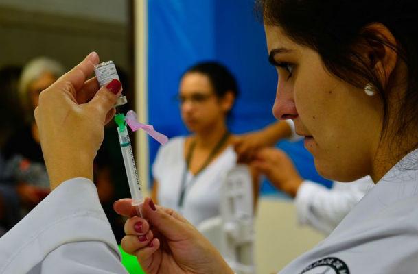 Imagem de profissional com seringa e frasco com dose de vacina (Foto: Rovena Rosa / Agência Brasil)