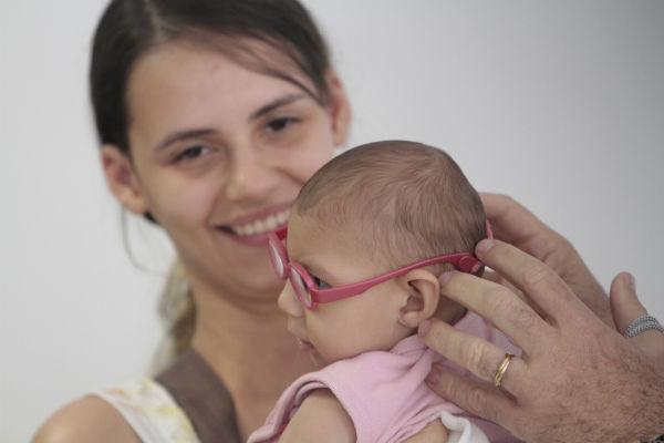 Foto de Nicole Cristina com a filha Helena, 7 meses. Diagnosticada com microcefalia, a criança tem problema na visão e ganhou óculos de grau (Foto: Guga Matos / JC Imagem)
