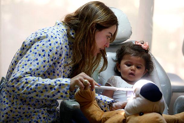 A odontopediatra Gabriela Trindade mostra à pequena Lara, 1 ano e 3 meses, como deve ser feita a higienização bucal (Foto: Diego Nigro/JC Imagem)