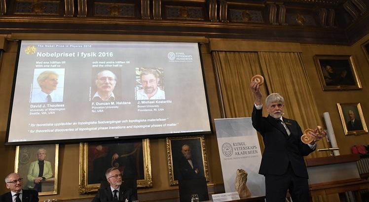 Thors Hans Hansson, membro do Comitê do Nobel, utiliza um pretzel, um bagel e um sonho de padaria para explicar a descoberta dos vencedores do Nobel de Física de 2016. AFP PHOTO / JONATHAN NACKSTRAND
