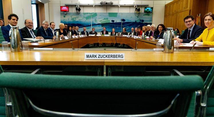 O Comitê Internacional com representação de nove países e uma cadeira e o nome do presidente-executivo do Facebook, Mark Zuckerberg, que foi convidado a depor e recusou o convite (AFP PHOTO / Gabriel SAINHAS / UK Parliament)