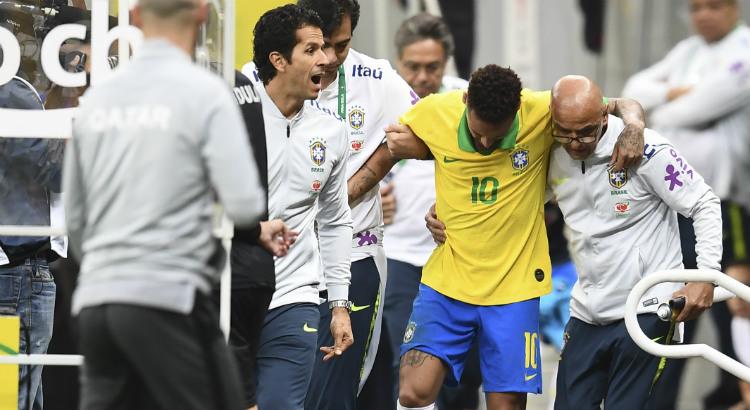 Neymar sendo auxiliado por membros da equipe após machucar-se durante o jogo Brasil x Catar (Imagem: Evaristo Sá / AFP)