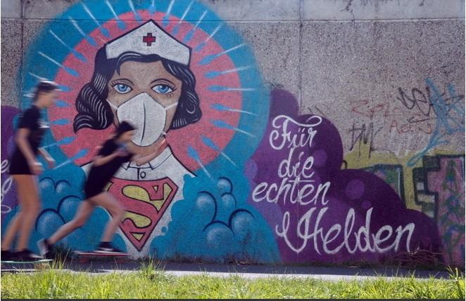 'Para os verdadeiros heróis' diz o grafiti em muro de Hamm, na Alemanha. O retrato mostra uma enfermeira com a roupa do Super-homem Foto: Leon Kuegeler / Reuters