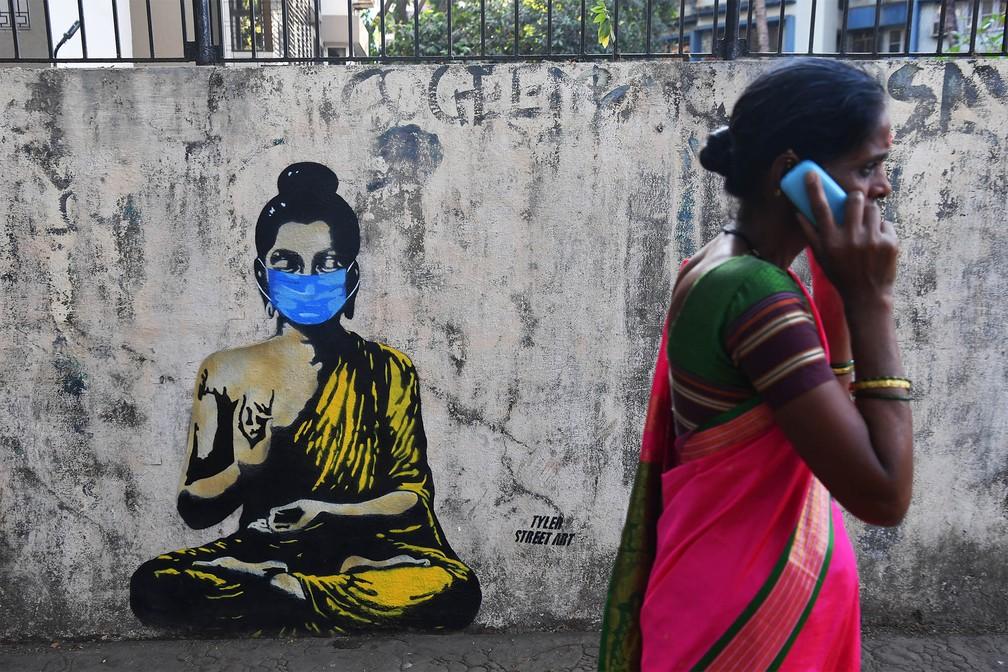 Grafite de Buda usando uma máscara para evitar contágio em tempos de coronavírus, em Mumbai, na Índia, na segunda-feira (16) — Foto: Indranil Mukherjee/AFP