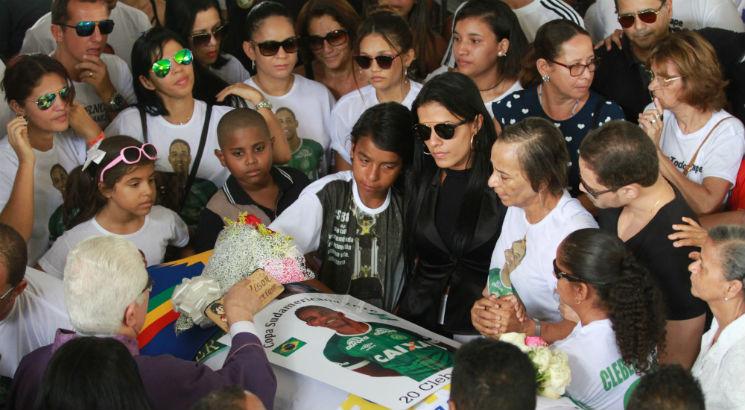 Esposa, mãe e filhos de Cléber Santana abraçados próximo ao caixão. Foto: Guga Matos/JC Imagem