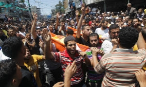 Pessoas levam corpo de palestino morto em um ataque aéreo israelense